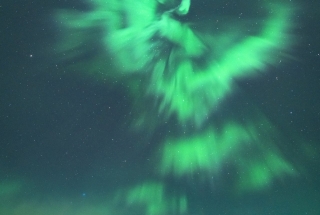 aurora dancing above the three sisters mountains in canmore at night in the winter