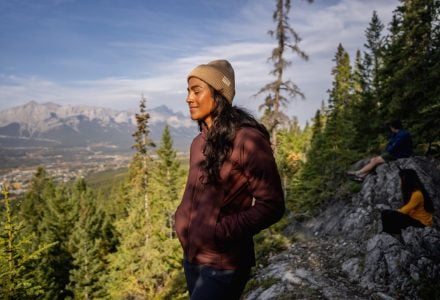 a woman enjoying the sunshine on a hike in the forest