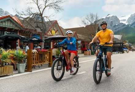 a couple biking on Main Street in downtown Canmore