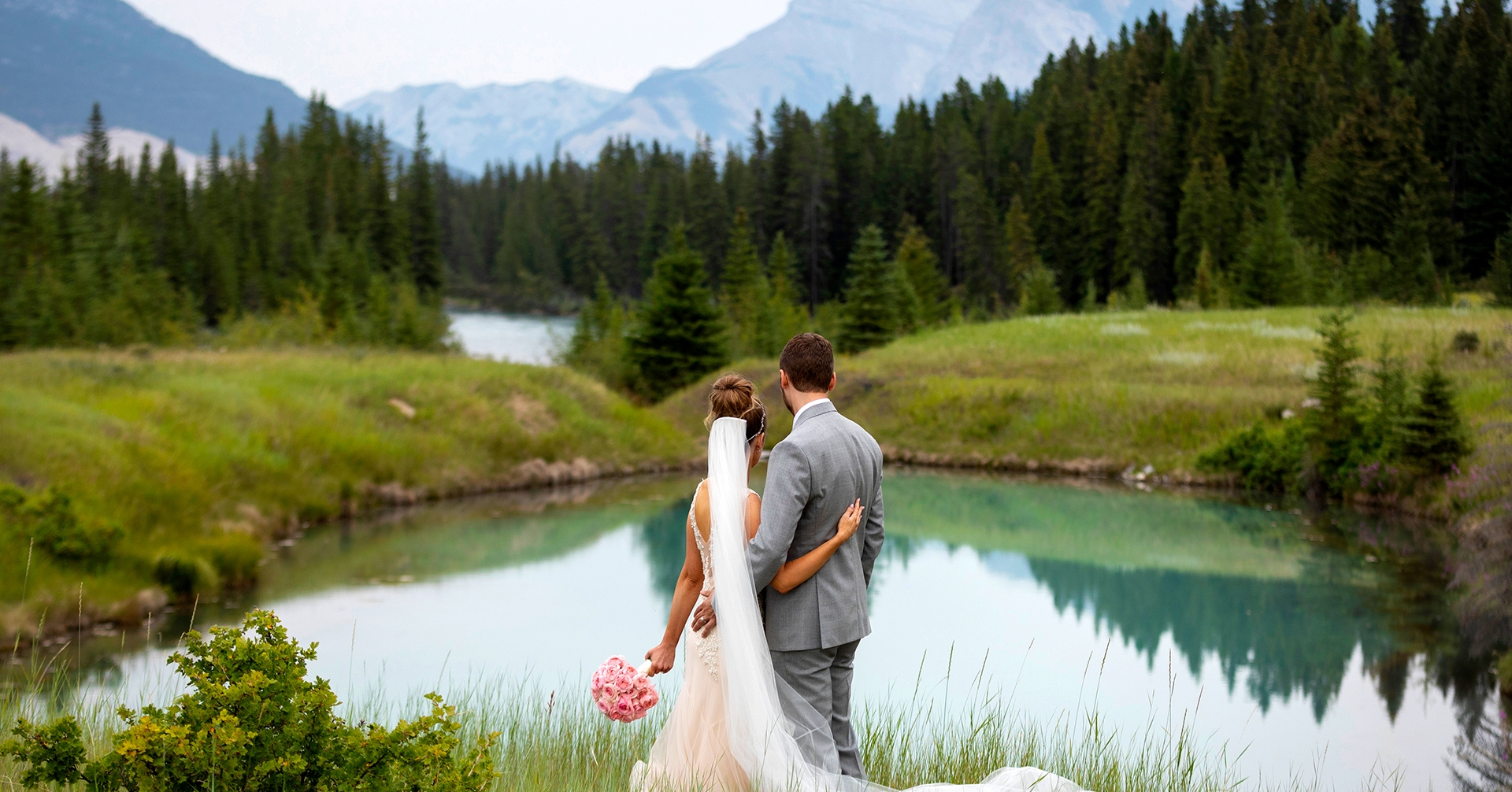 a recently married couple gazing at the lakes and mountains in kananaskis