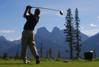 a man golfing at silvertip resort with the three sisters mountains in the background