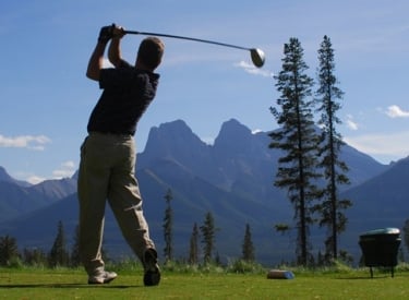 a man golfing at silvertip resort with the three sisters mountains in the background