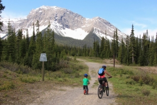 a woman and child cycling on the trails in kananaskis