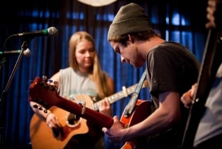 a group performing a show with guitars and microphones at artsplace