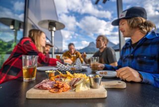 a group enjoying food and drinks on the cangolf outdoor patio in the summer