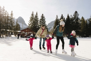 a family ice skating on the canmore downtown pond in the winter