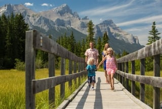 a family walking on policeman's creek boardwalk in the summer