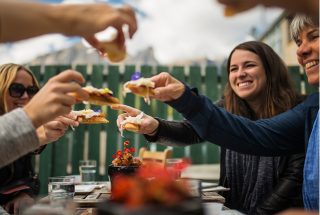 a group sitting at an outdoor table enjoying appetizers