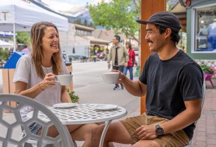 two people enjoying coffee on the outdoor patio at eclipse coffee roastery on canmore's main street
