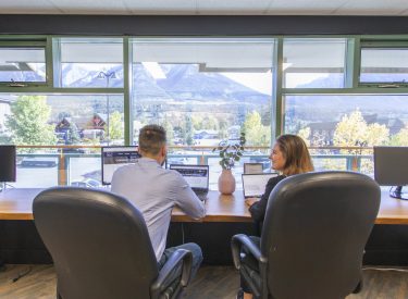 two people utilizing the meeting room in e=mc2 with mountain views out the window
