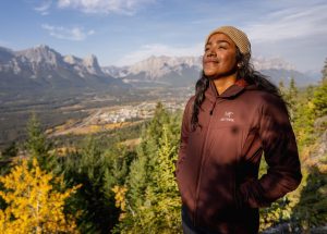 a woman basking in the sun on a hike in Canmore with mountains in the background