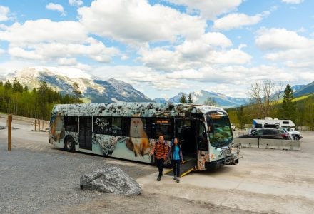 a couple offloading a Roam Transit bus at Grassi Lakes Trailhead