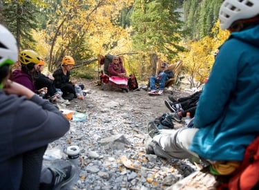 A group on an adventure tour with souls of miistaki listening to Indigenous elders share stories