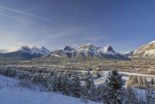 a landscape shot of mountain ranges above the town of canmore in the winter