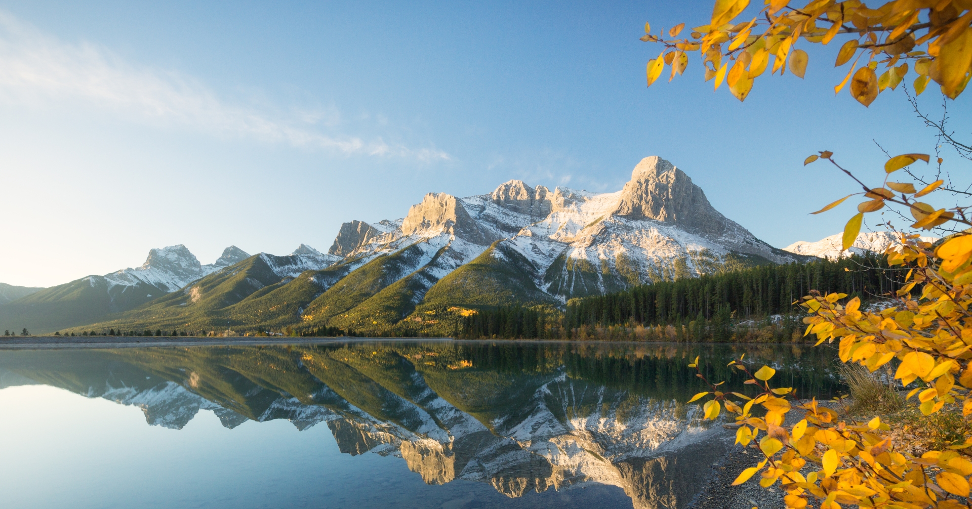 ha ling peak reflecting in the rundle forebay with fall leaves in the foreground