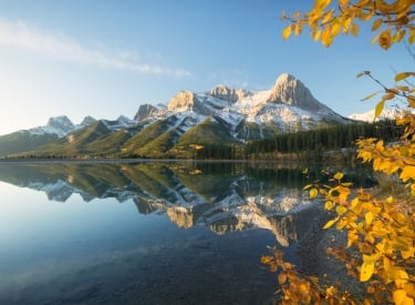 ha ling peak reflecting in the rundle forebay with fall leaves in the foreground