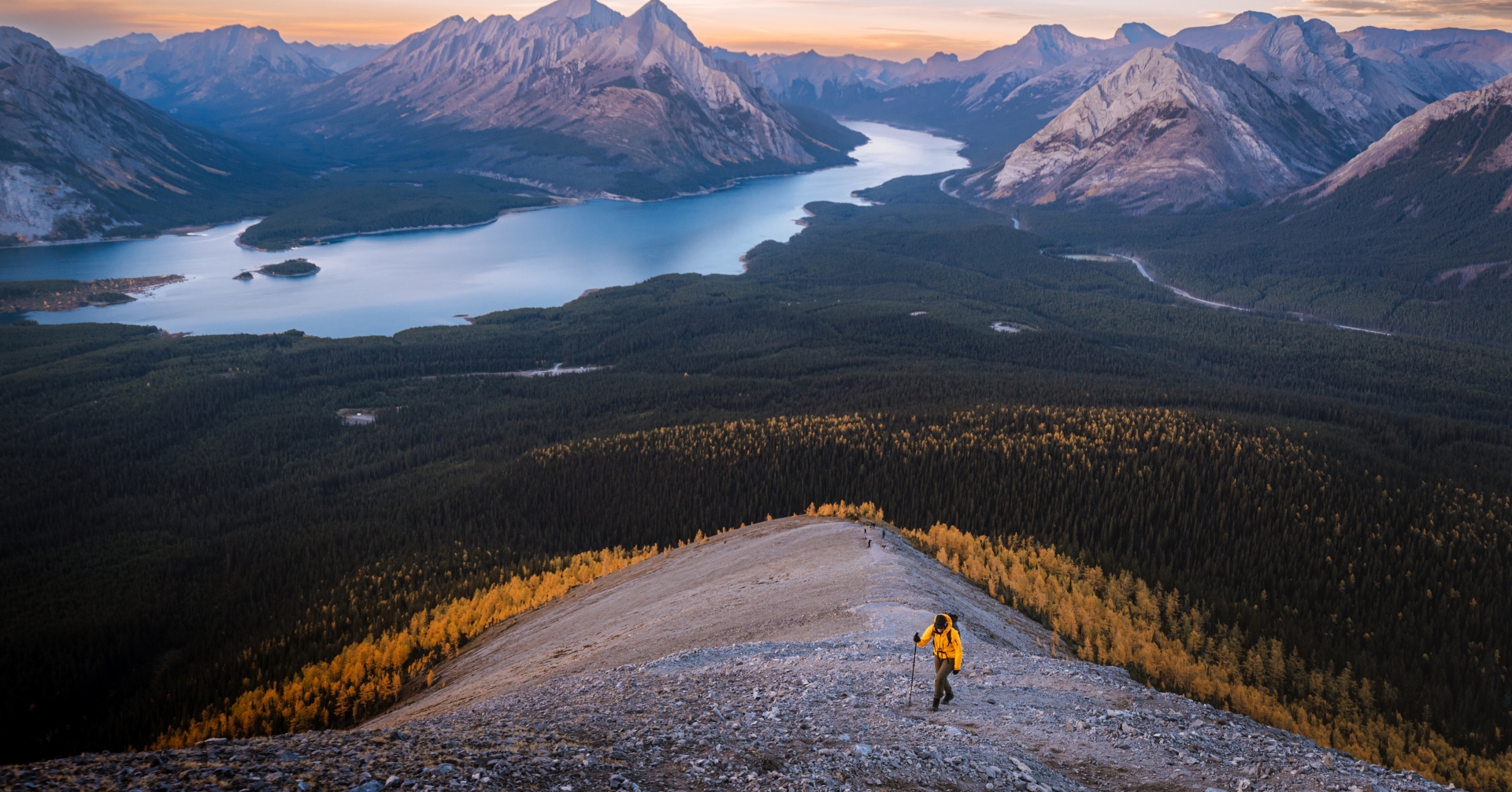 Hiker ascending Tent Ridge at golden hour in Kananaskis.