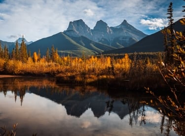 the three sisters mountain reflecting in the pond at three sisters viewpoint with fall colours