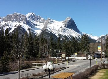 Main street of Canmore with the mountains in the background, including Ha Ling.