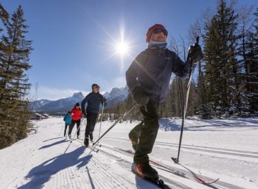 People cross-country skiing on trails at the Canmore Nordic Centre.