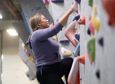 A climber on the climbing wall of the Canmore Climbing Gym