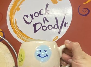 A painted mug and the logo of Crock a Doodle