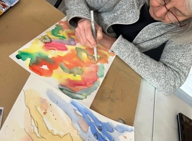 A person painting at a Listen Studio workshop